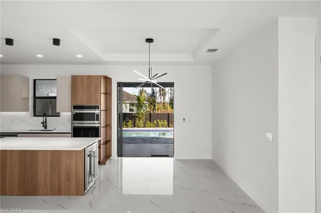 a kitchen with a sink a counter top space stainless steel appliances and cabinets