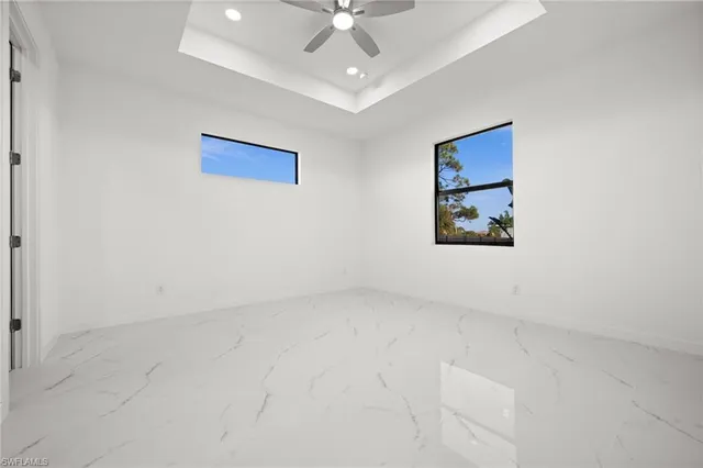 an empty room with a ceiling fan and window