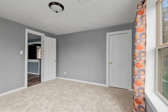 an empty room with windows and closet