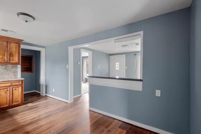 a view of a hallway with wooden floor and staircase