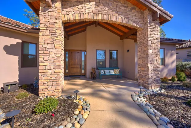 a kitchen with stainless steel appliances granite countertop a stove top oven a refrigerator a sink and a dining table with wooden floor