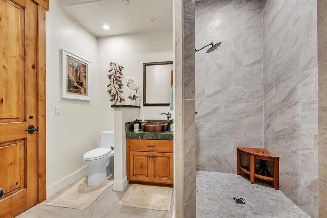 a spacious bedroom with a bed a table and a chandelier