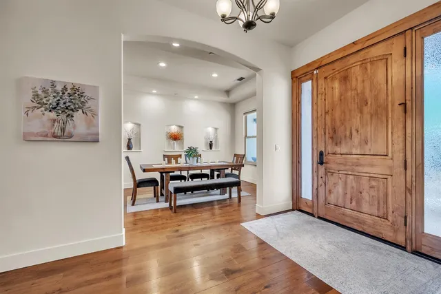 a spacious bedroom with a bed painting on the wall and a window
