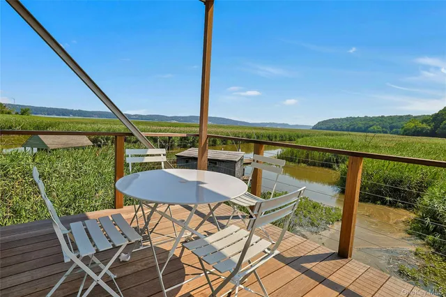 a view of a chairs and table in patio with a lake view