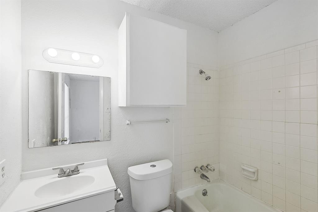 2637 West Randol Mill Road, Unit C Arlington, TX 76012 - Photo 6 of 7 a bathroom with a toilet a sink a mirror and vanity