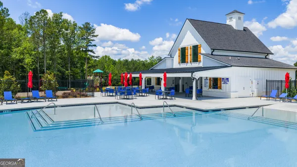 a view of house with swimming pool and sitting area