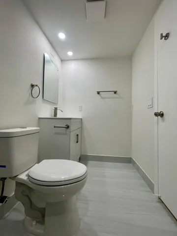 a bathroom with a toilet sink and mirror