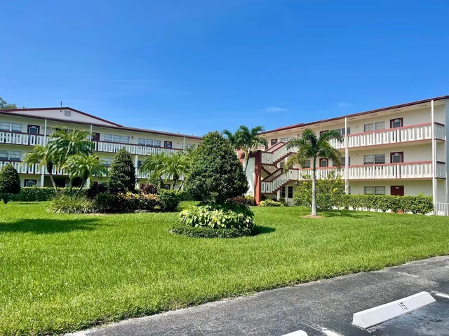 a view of a building with a big yard and potted plants