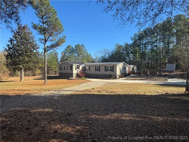 a swimming pool view with large trees and a big yard