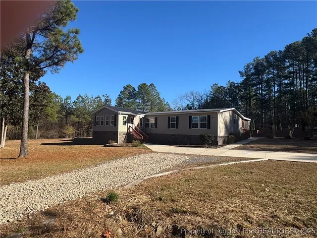 a front view of a house with a yard and trees