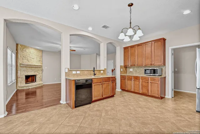 a large kitchen with granite countertop a stove and a sink