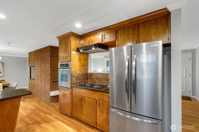 a metallic refrigerator freezer sitting in a kitchen