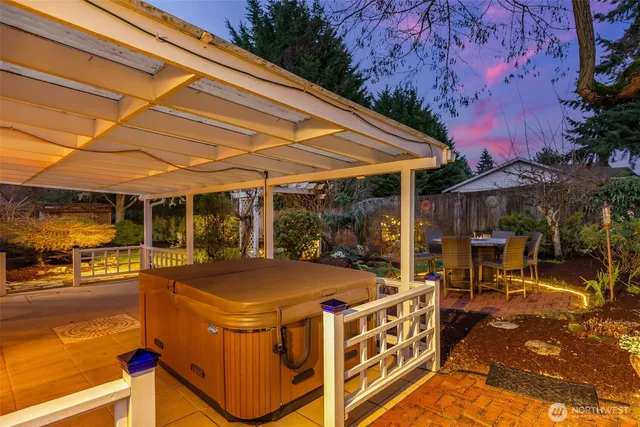 a view of a patio with table and chairs under an umbrella with a barbeque