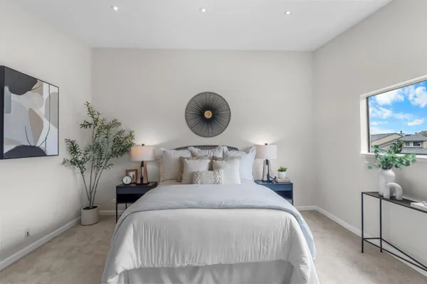 a bedroom with bed and a potted plant