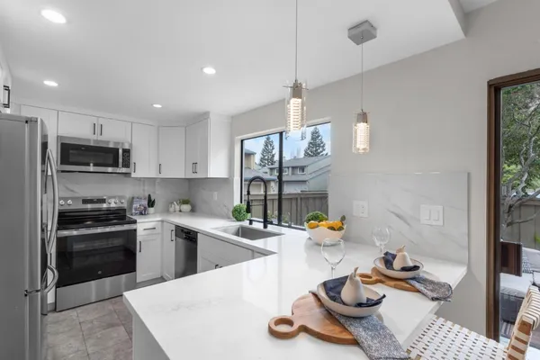 a kitchen with a sink a stove and chairs with wooden floor