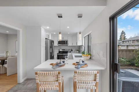 a kitchen with a sink a stove and chairs
