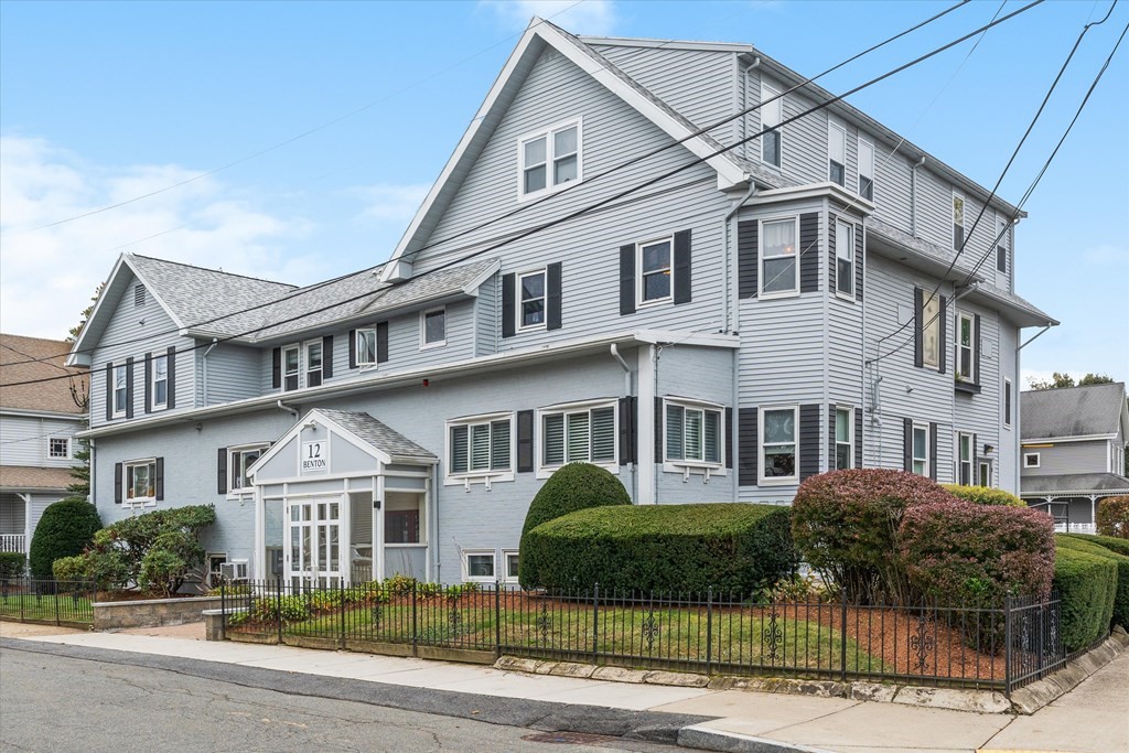 a view of a white building among the street with palm trees