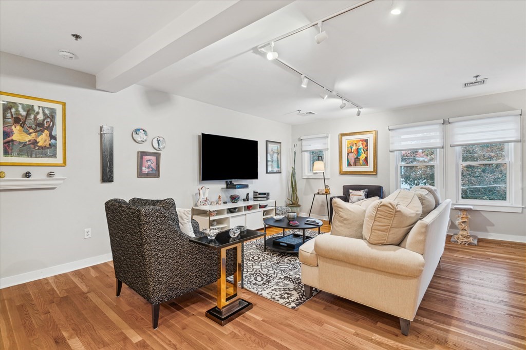 12 Benton Street, Unit 4 Stoneham, MA 02180 - Photo 11 of 35 a living room with furniture flat screen tv and wooden floor