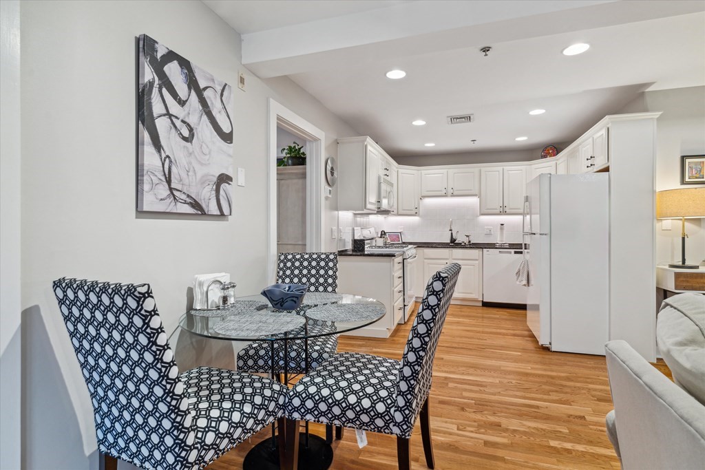 12 Benton Street, Unit 4 Stoneham, MA 02180 - Photo 16 of 35 a kitchen with stainless steel appliances granite countertop a dining table and chairs
