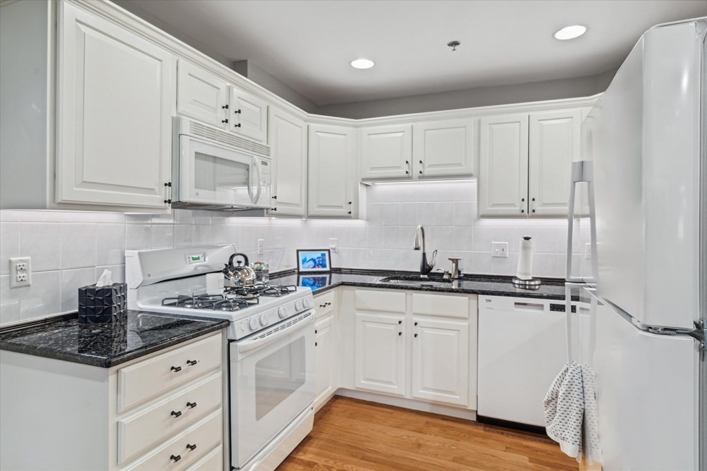 12 Benton Street, Unit 4 Stoneham, MA 02180 - Photo 18 of 35 a kitchen with granite countertop a sink a stove and cabinets