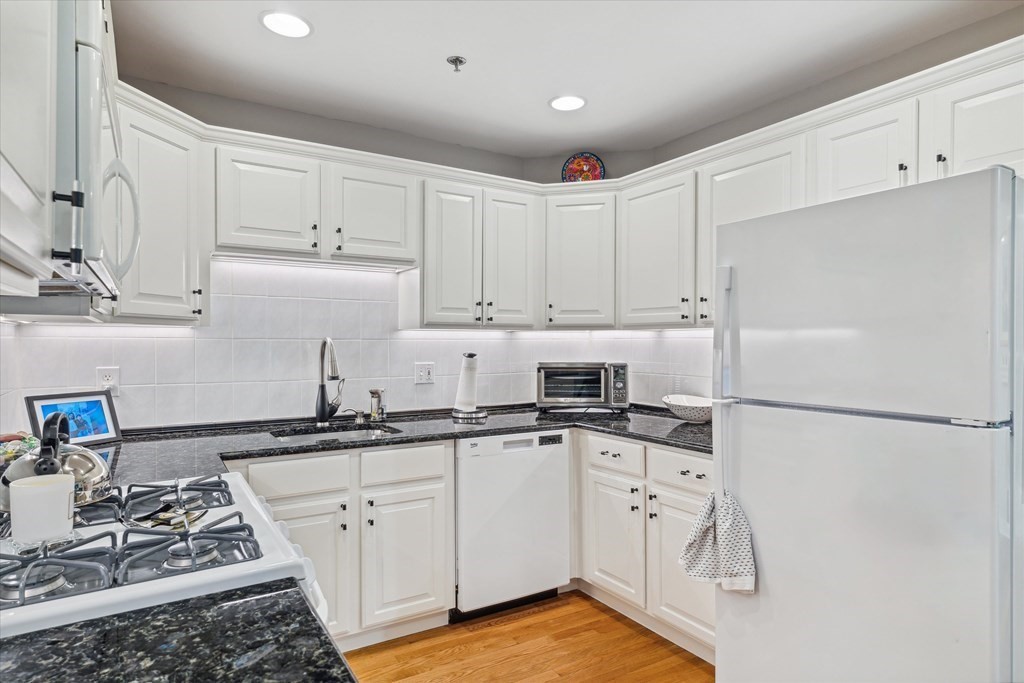 12 Benton Street, Unit 4 Stoneham, MA 02180 - Photo 19 of 35 a kitchen with granite countertop a sink stove and refrigerator