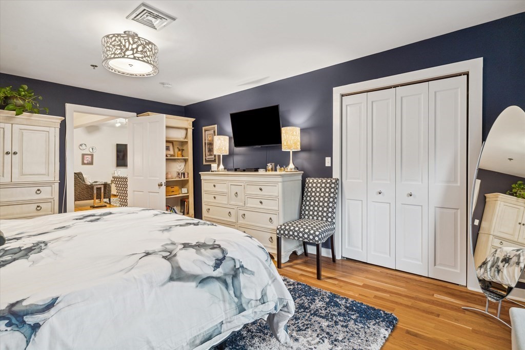 12 Benton Street, Unit 4 Stoneham, MA 02180 - Photo 24 of 35 a spacious bedroom with a bed and a flat screen tv