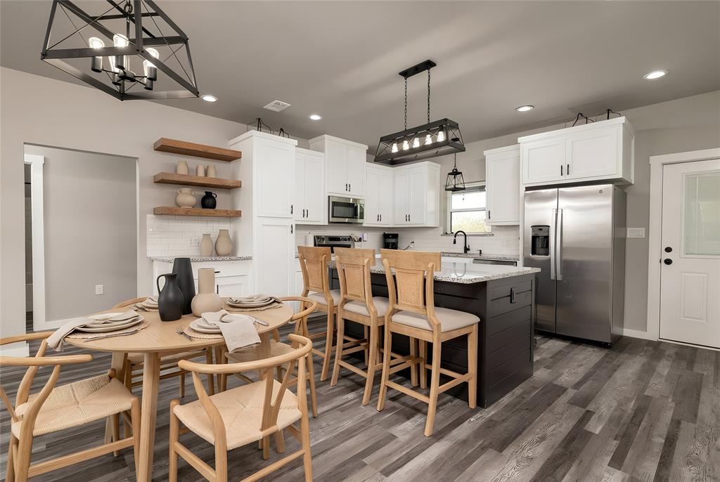 115 Valley Ridge Drive Bridgeport, TX 76426 - Photo 12 of 35 a kitchen with stainless steel appliances kitchen island granite countertop a table chairs and a refrigerator