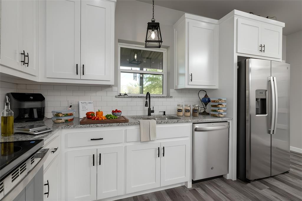 115 Valley Ridge Drive Bridgeport, TX 76426 - Photo 15 of 35 a kitchen with white cabinets and stainless steel appliances