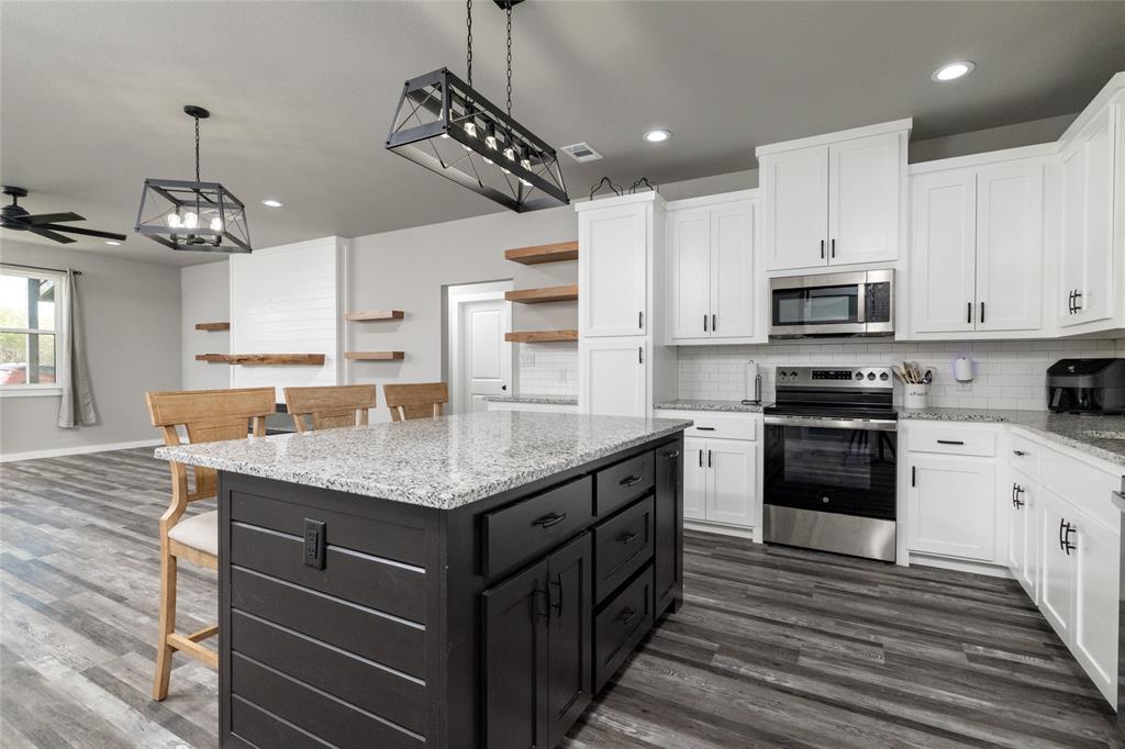 115 Valley Ridge Drive Bridgeport, TX 76426 - Photo 16 of 35 a kitchen with stainless steel appliances granite countertop a stove oven and a refrigerator