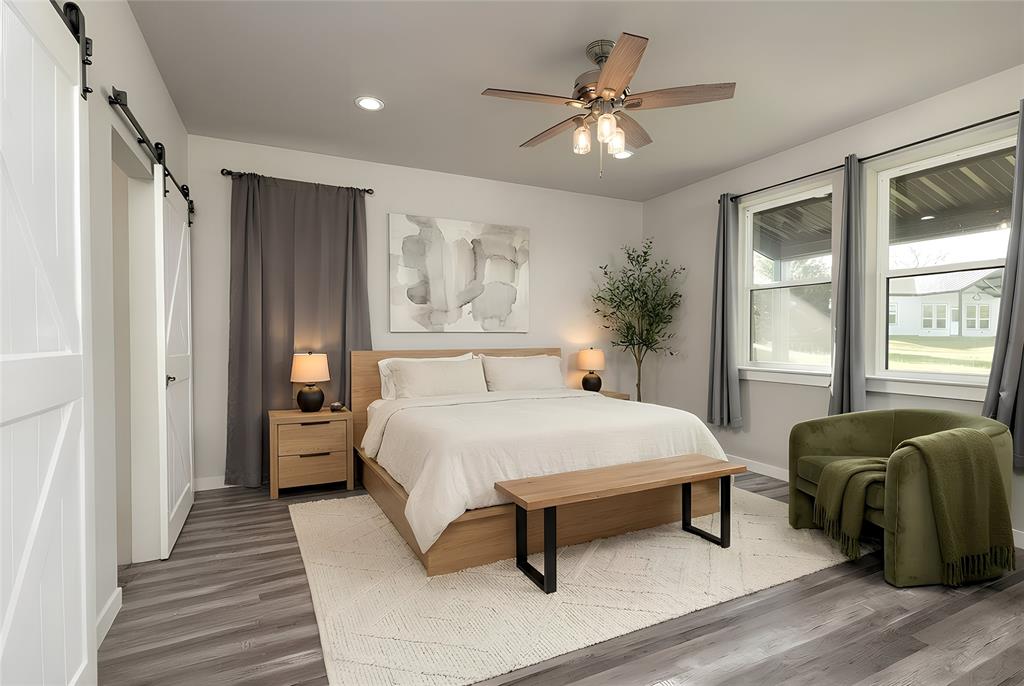 115 Valley Ridge Drive Bridgeport, TX 76426 - Photo 18 of 35 a spacious bedroom with a bed a chandelier and a window