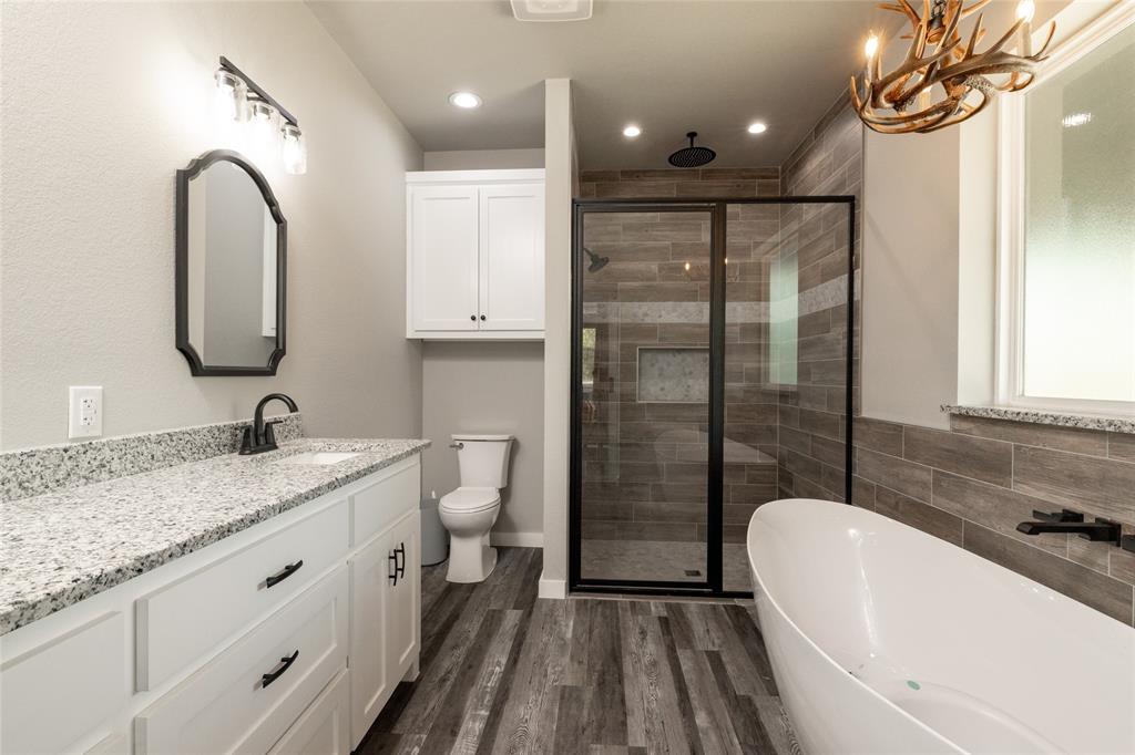 115 Valley Ridge Drive Bridgeport, TX 76426 - Photo 21 of 35 a bathroom with a granite countertop sink a toilet and shower