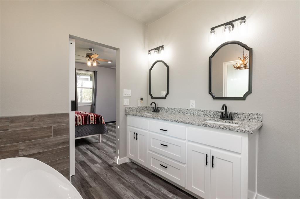 115 Valley Ridge Drive Bridgeport, TX 76426 - Photo 24 of 35 a en suite bathroom with a double vanity sink and a mirror
