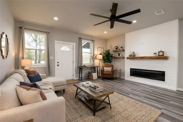 a living room with furniture a flat screen tv and a fireplace
