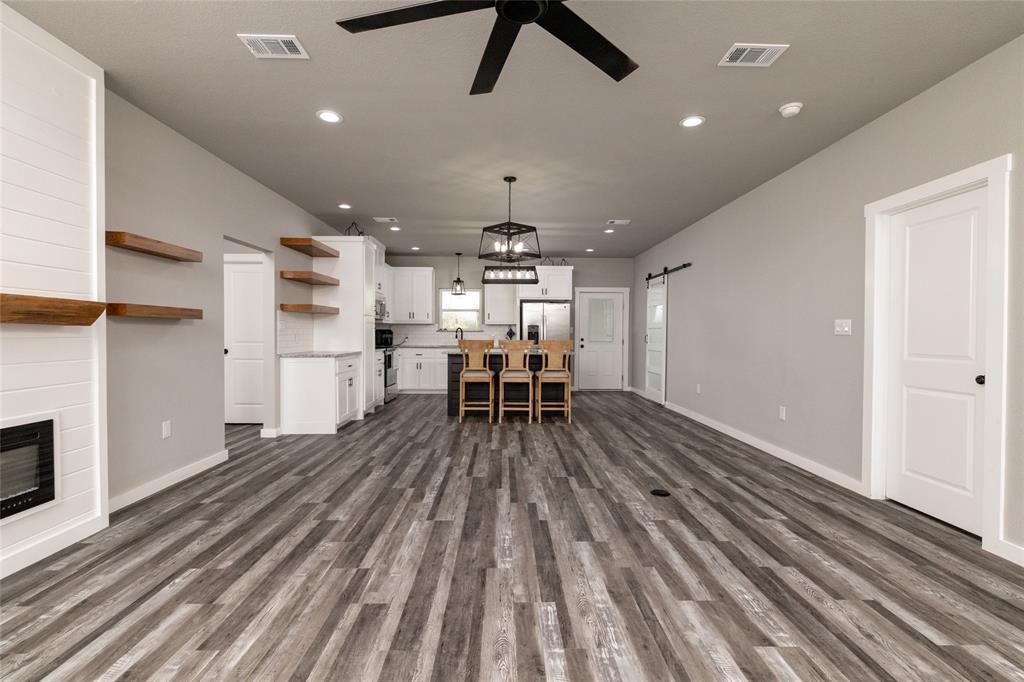 115 Valley Ridge Drive Bridgeport, TX 76426 - Photo 5 of 35 a kitchen with stainless steel appliances a dining table chairs stove and cabinets
