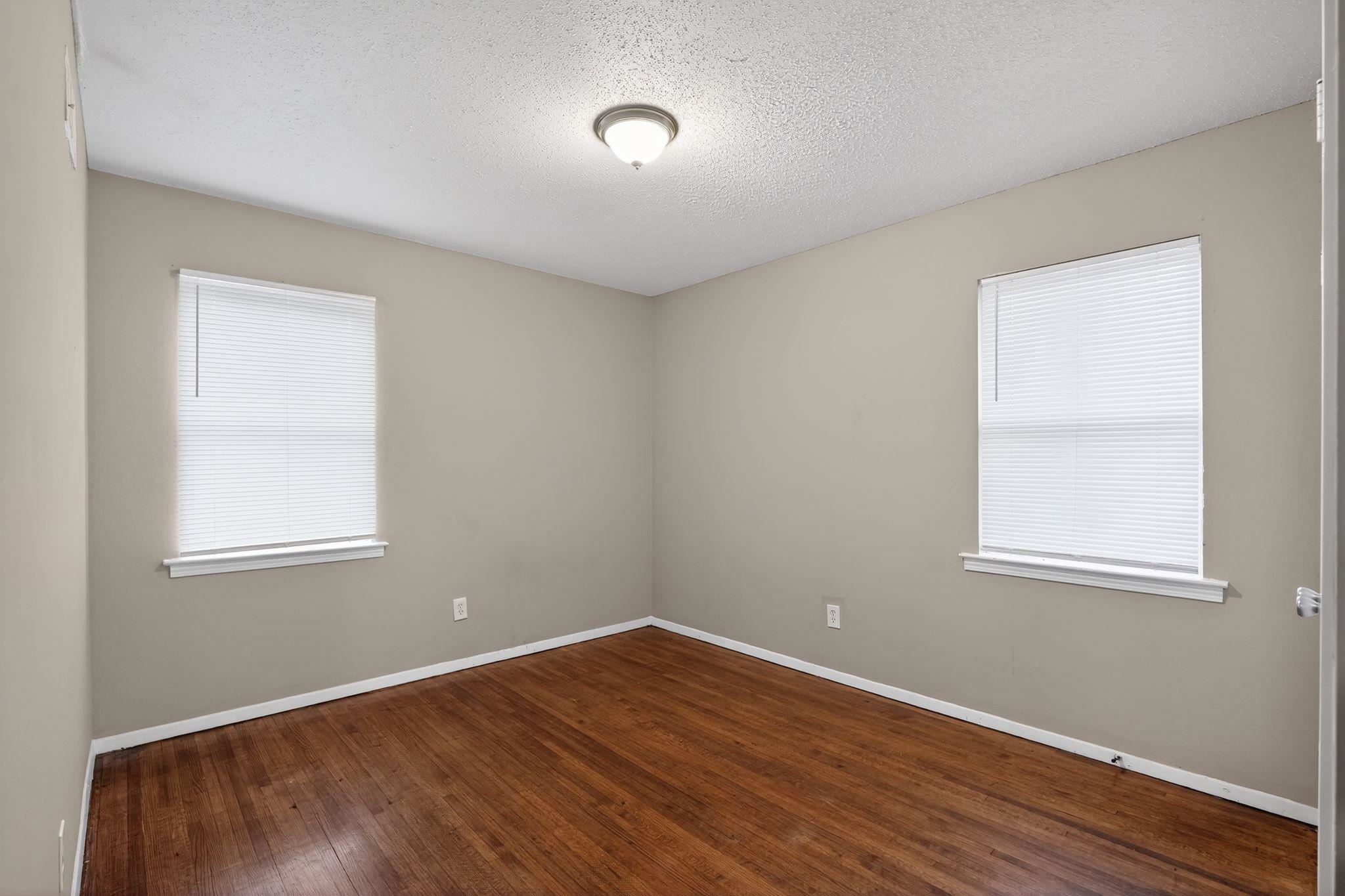 4314 Ford Road Memphis, TN 38109 - Photo 13 of 31 an empty room with wooden floor and windows
