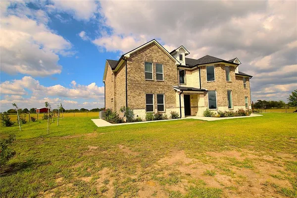 a front view of a house with a big yard