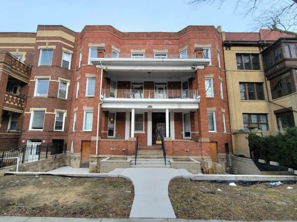 a front view of a residential apartment building with a yard