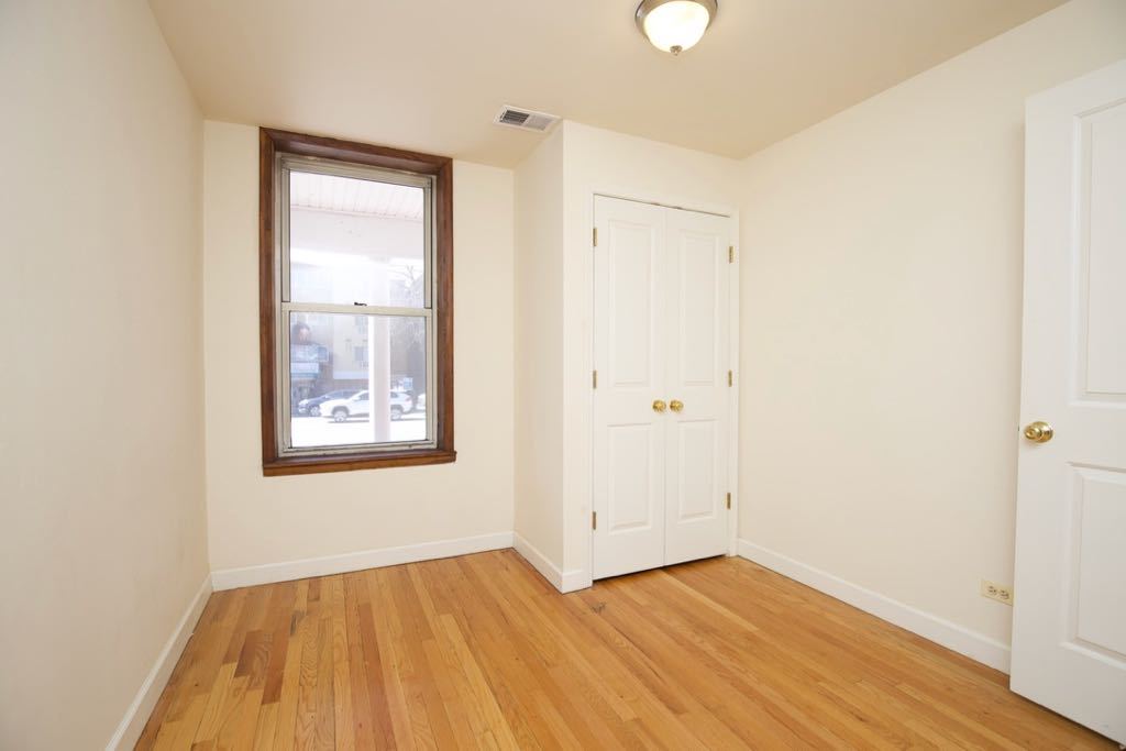 6713 North Sheridan Road, Unit 1N Chicago, IL 60626 - Photo 8 of 20 an empty room with wooden floor and windows
