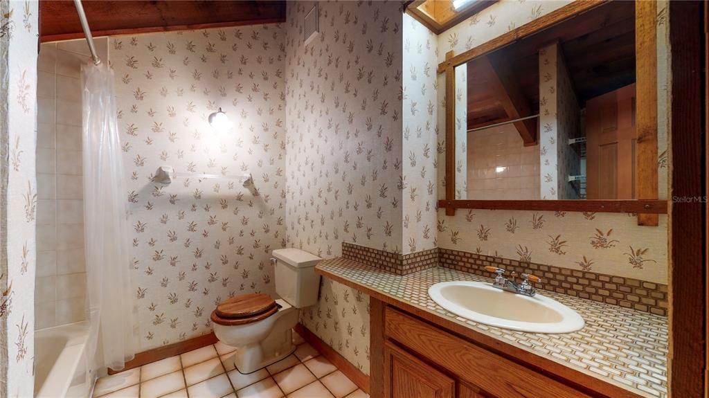 19803 Reading Road Lutz, FL 33558 - Photo 35 of 48 a bathroom with a granite countertop sink toilet and a mirror