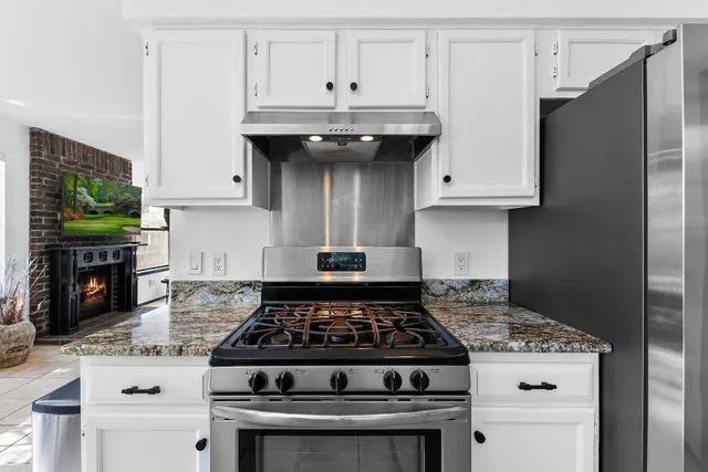 a stove top oven sitting inside of a kitchen