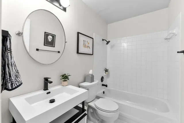 a bathroom with a sink mirror bathtub and toilet