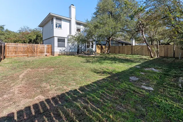 a view of a house with backyard and a tree