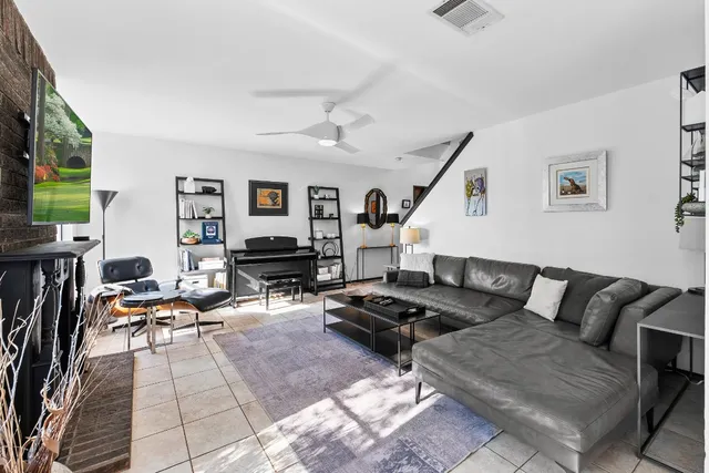 a living room with furniture kitchen view and a flat screen tv
