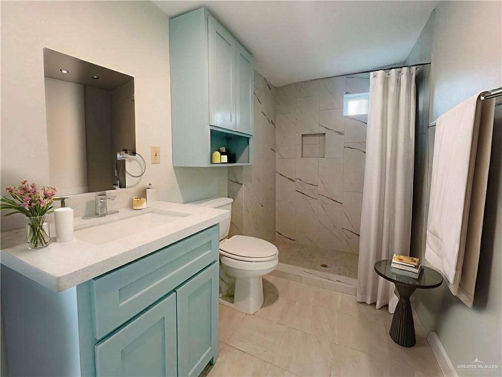 302 La Jara Avenue Santa Rosa, TX 78593 - Photo 12 of 13 a bathroom with a sink a toilet and shower