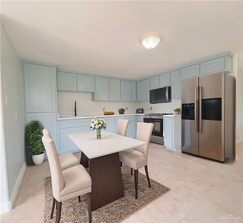 302 La Jara Avenue Santa Rosa, TX 78593 - Photo 4 of 13 a kitchen with a dining table chairs and refrigerator