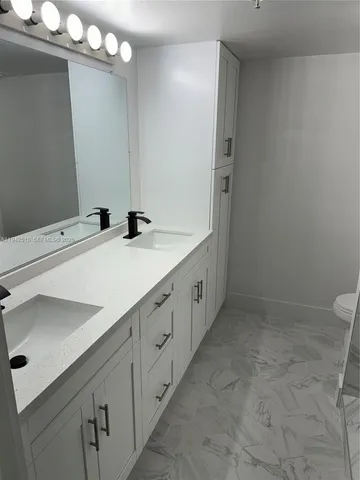 a bathroom with a double vanity sink and a mirror