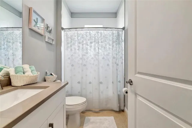 a bathroom with a granite countertop sink a toilet and shower