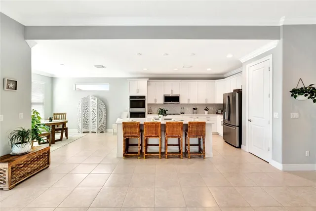 a large kitchen with stainless steel appliances a refrigerator and a counter space