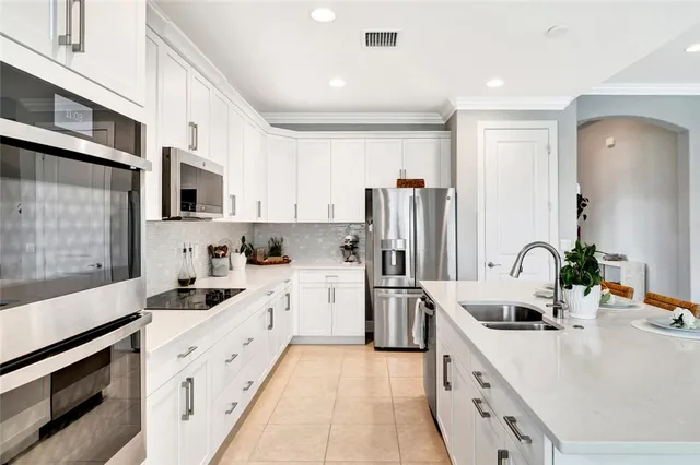 a kitchen with stainless steel appliances a sink stove refrigerator and cabinets