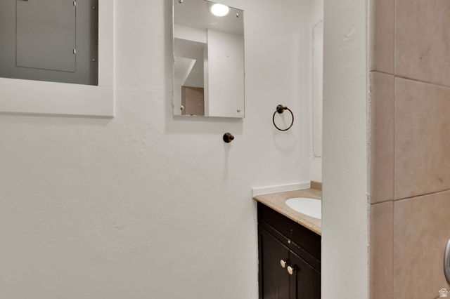 360 400 North Centerville, UT 84014 - Photo 27 of 30 Compact vanity with a built-in sink, stone-finish countertop, and dark wood-finish cabinetry